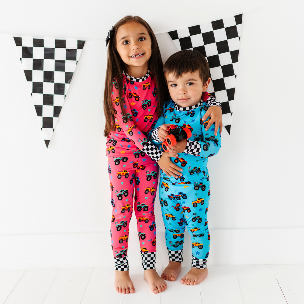 
                      
                        Brother and sister in sibling matching monster truck pajamas by Kiki and Lulu
                      
                    