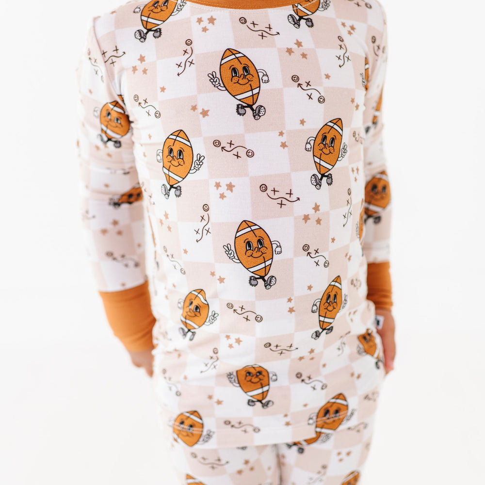 Child wearing a football themed pajamas on a white background