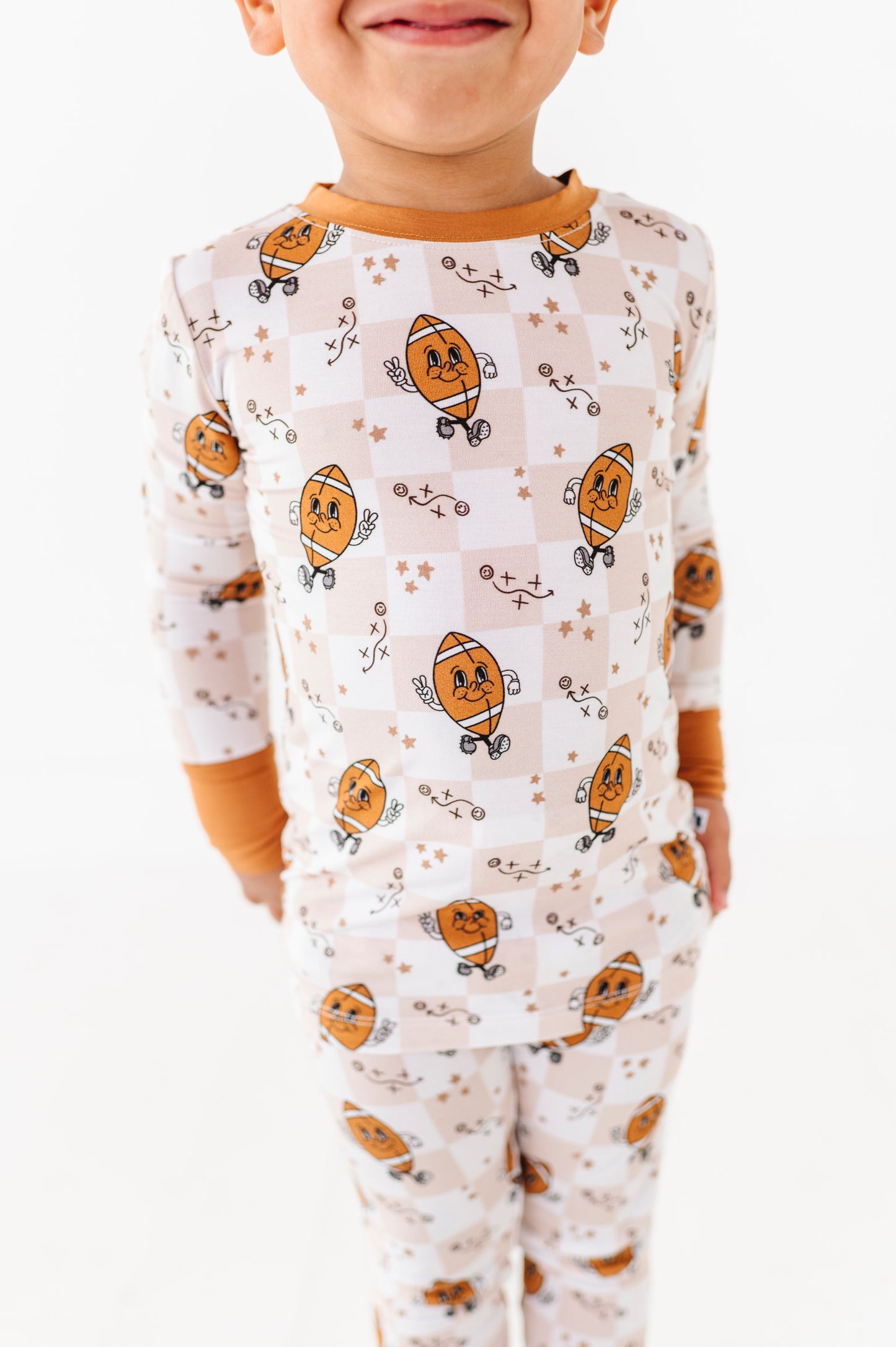 Child wearing a football themed pajamas on a white background
