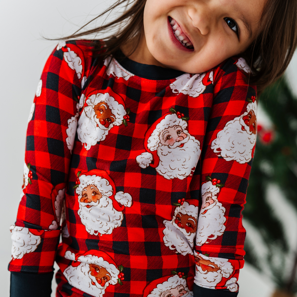 Girl in Buffalo Plaid Santa pajamas by kiki and lulu