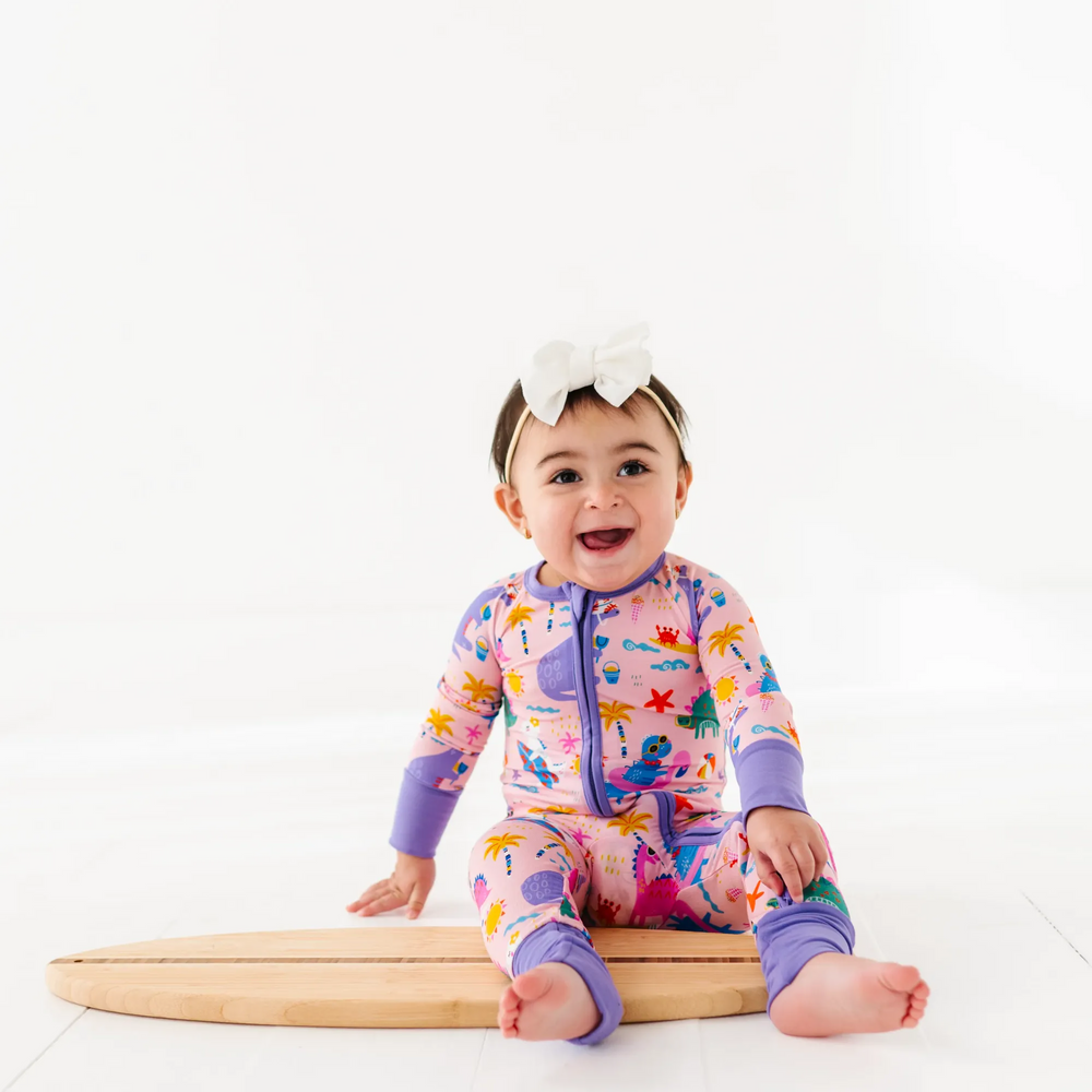 
                      
                        Baby Girl in dinosaur pajamas by Kiki and Lulu
                      
                    