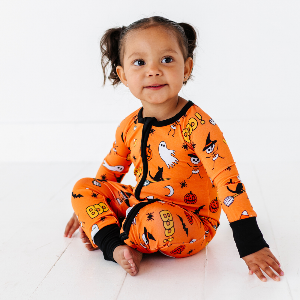 Girl in orange Halloween pajamas by Kiki and Lulu